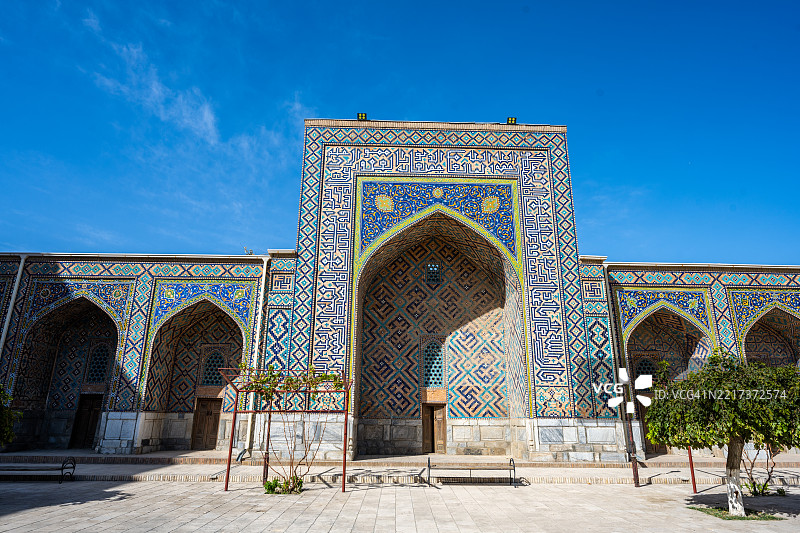 在萨马尔罕，晴空下的提利亚-卡里宗教学校华丽的瓷砖门廊。图片素材