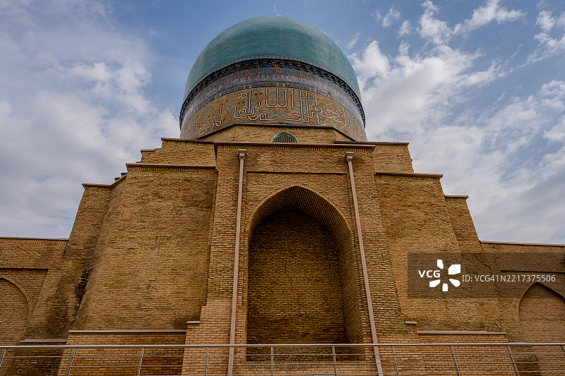 乌兹别克斯坦沙赫里萨布兹的科克古姆巴兹清真寺后视图，突显其宏伟的砖基和青绿色圆顶。图片素材