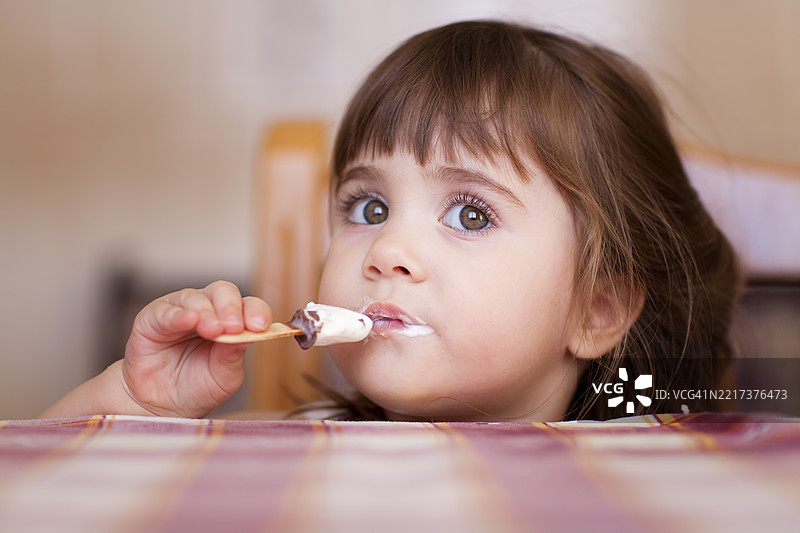 小女孩坐在桌子旁享受甜点图片素材