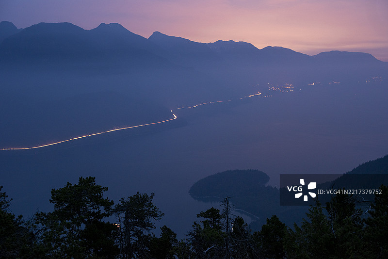 黄昏时分的山间公路和交通的鸟瞰图图片素材