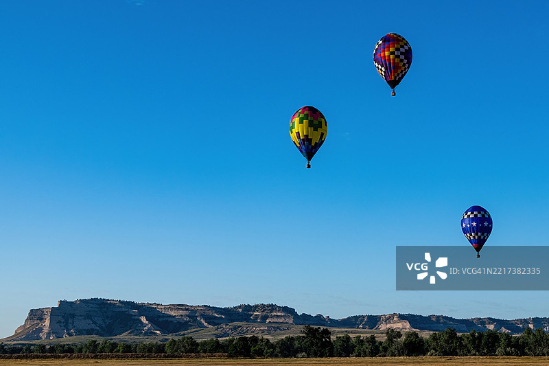 低角度视图下的人们在清澈的蓝天中滑翔伞，斯科茨布拉夫，内布拉斯加州，美国图片素材