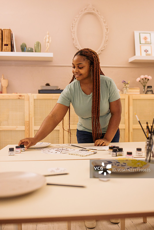 女工匠在工作室准备进行盘子艺术创作图片素材