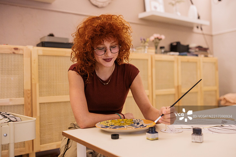 女工在陶瓷盘上手绘装饰图案图片素材