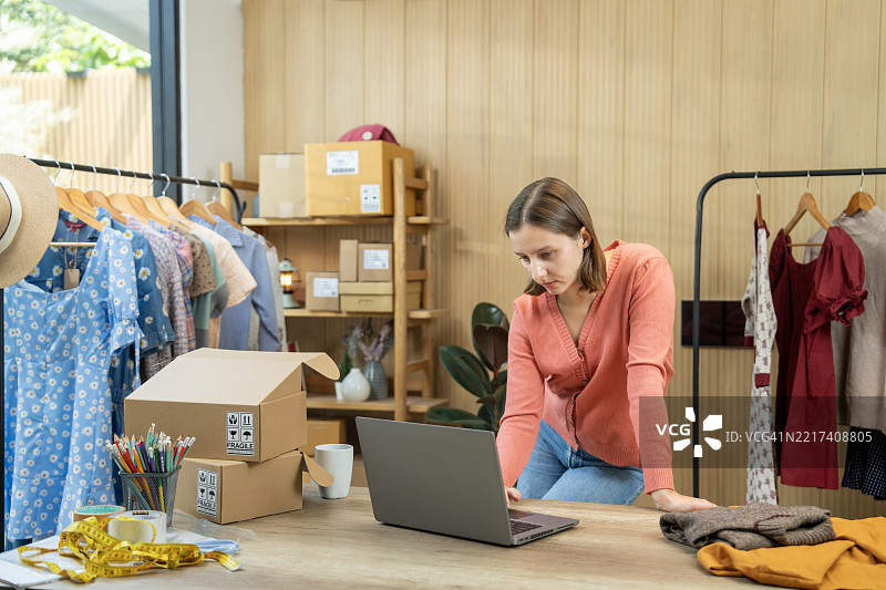 时尚店内的在线卖家在使用笔记本电脑工作图片素材