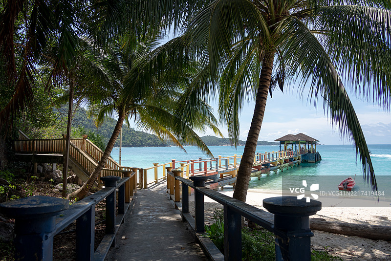 阳光明媚的热带度假岛屿的码头和清澈的海水图片素材
