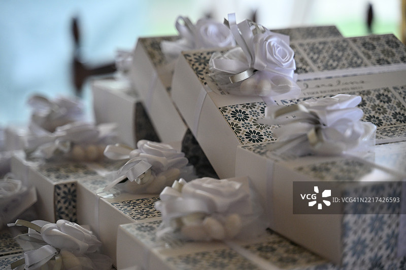 婚礼宾客桌上的花卉丝带装饰礼品盒特写堆叠。图片素材