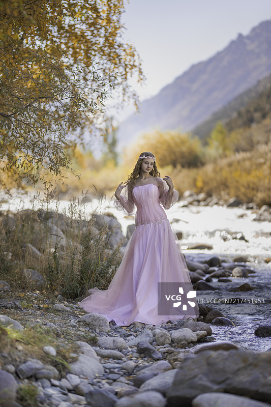 一个穿着粉色裙子的女孩在山谷中图片素材