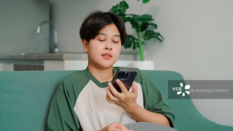 亚洲女性在家中使用手机图片素材