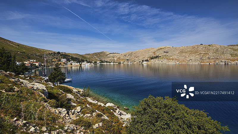 清澈天空下的海岸，蓝色海水与丘陵景观，埃姆波里奥湾，希腊西米岛，多德卡尼斯群岛，希腊，欧洲图片素材