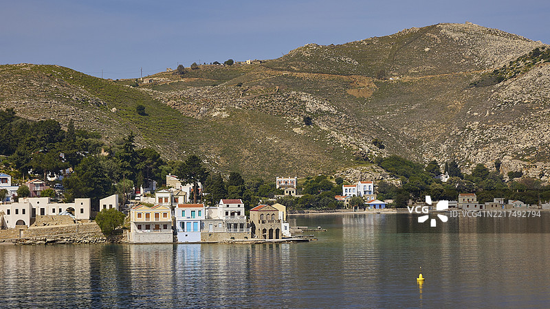 海边的小村庄,五彩斑斓的房屋和绿色的山丘,埃姆波里奥湾,埃姆波里奥,西米岛,多德卡尼斯群岛,希腊,欧洲图片素材