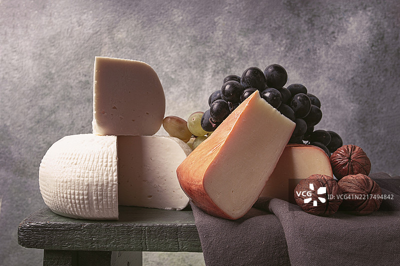 格鲁吉亚奶酪，伊梅列季奶酪和熏制苏鲁古尼，葡萄，坚果，放在切菜板上，格鲁吉亚美食，无人。图片素材