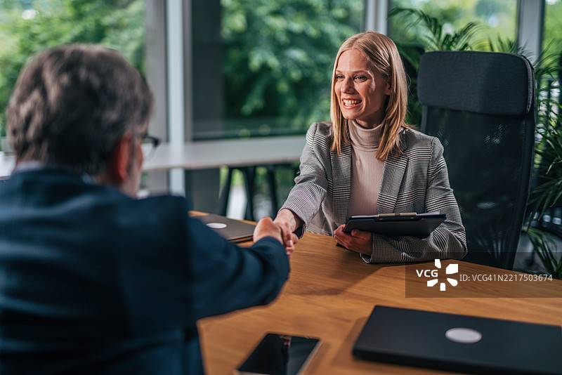 女商人与经理在成功的面试后握手。图片素材