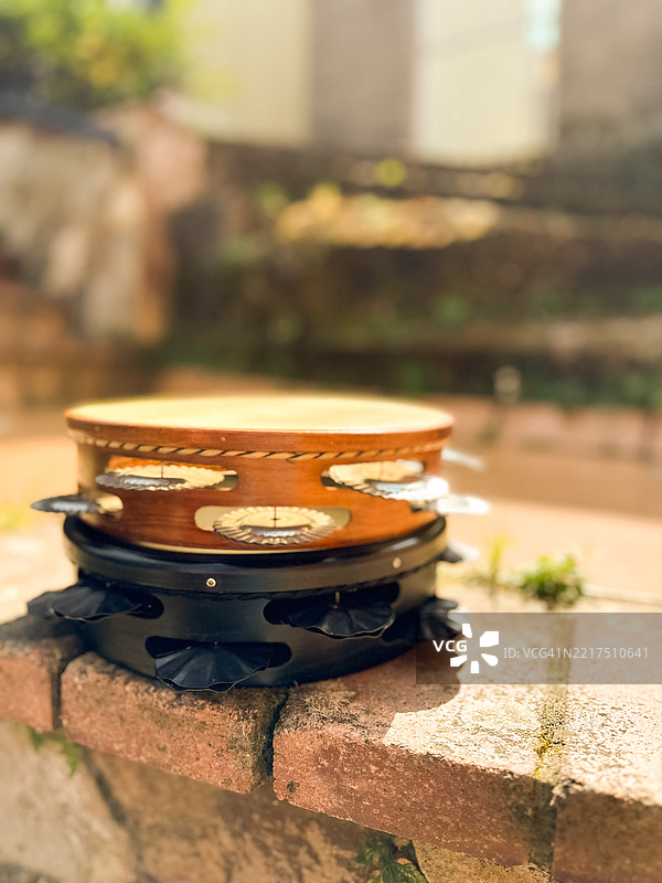 阳光下堆叠在乡村砖块上的传统手鼓图片素材