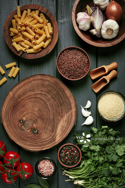 食物概念，木质切菜板，放在木桌上，配有食材、香料和草药，俯视图，竖向，无人。图片素材