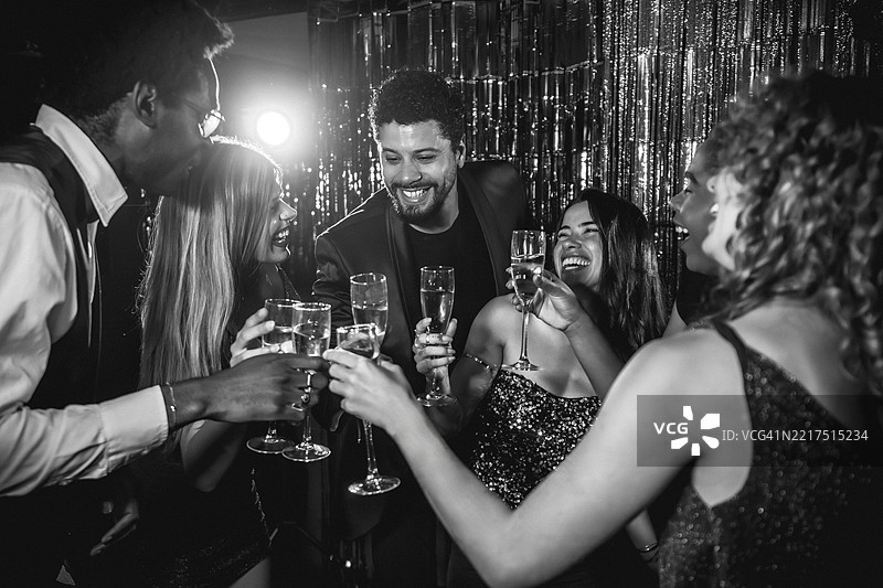 快乐的朋友们在华丽的派对上举杯庆祝，享受夜生活。图片素材