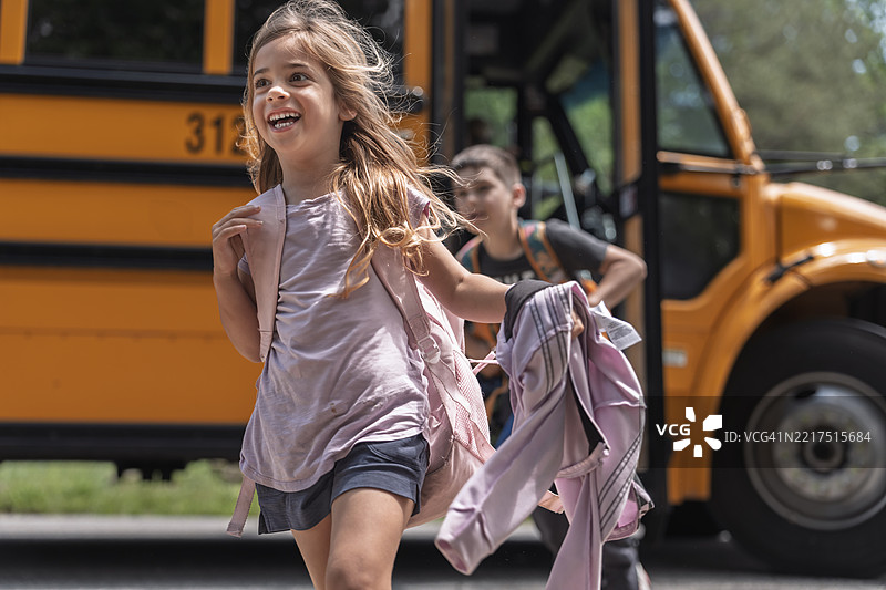5岁女孩和9岁哥哥下校车图片素材
