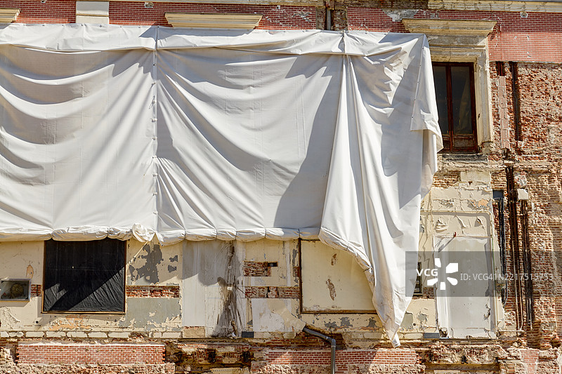 正在修复中的建筑物上覆盖着白色防水布图片素材
