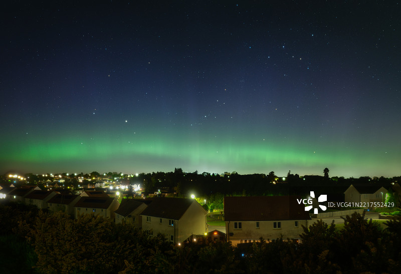 住宅区上空的绿色极光弧形光带图片素材