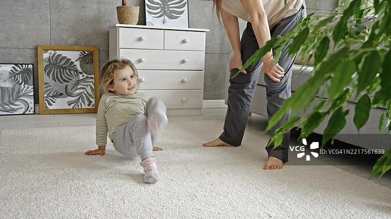 家庭乐趣。母亲和孩子一起玩杂技。图片素材