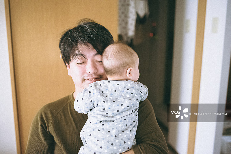 父亲拥抱着他的孩子。图片素材