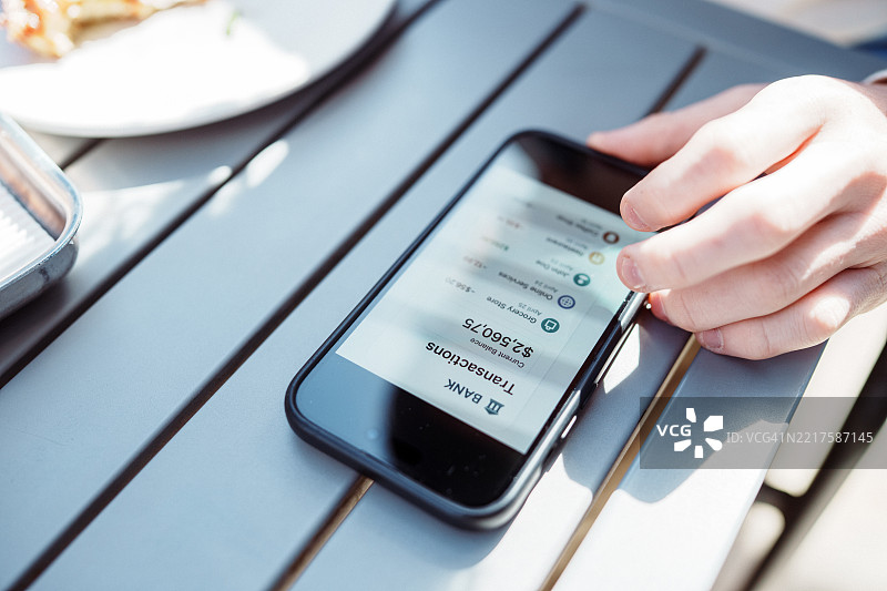 无法辨认的白人个体正在使用手机上的数字钱包应用查看银行交易记录图片素材
