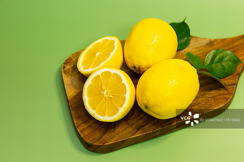 新鲜柠檬切片特写，放在木砧板上图片素材