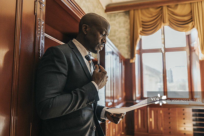 专注的光头商人在办公室查看报告图片素材