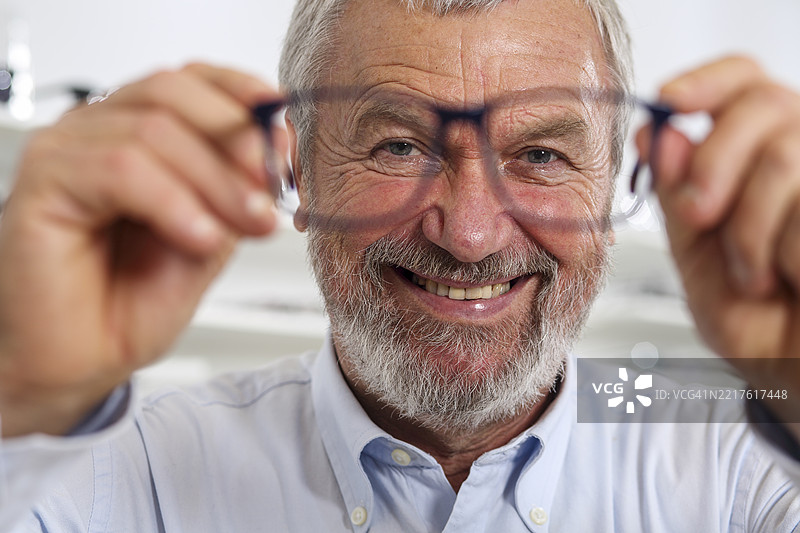 老年人手持彩色眼镜朝向镜头图片素材