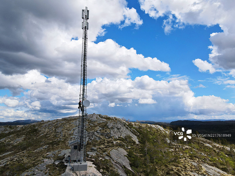 工程师在大型钢铁塔上工作的公用设施基础设施工人，使用无线电链接、微波、4G和5G。图片素材