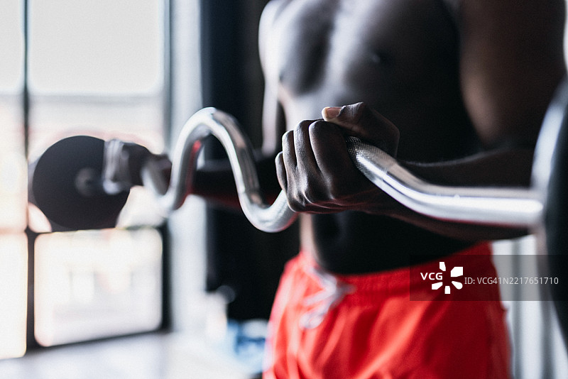 一个男人在锻炼时举起杠铃的特写镜头图片素材