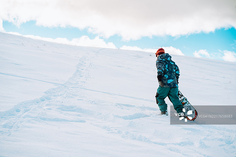 滑雪者在阳光明媚的日子里走上雪山图片素材