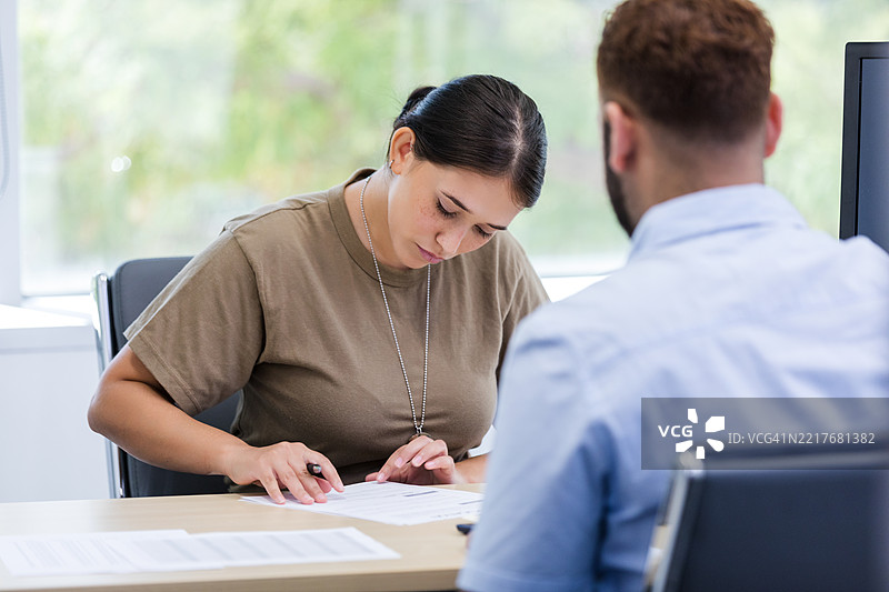 女性退伍军人与顾问一起阅读文件，心理健康支持图片素材