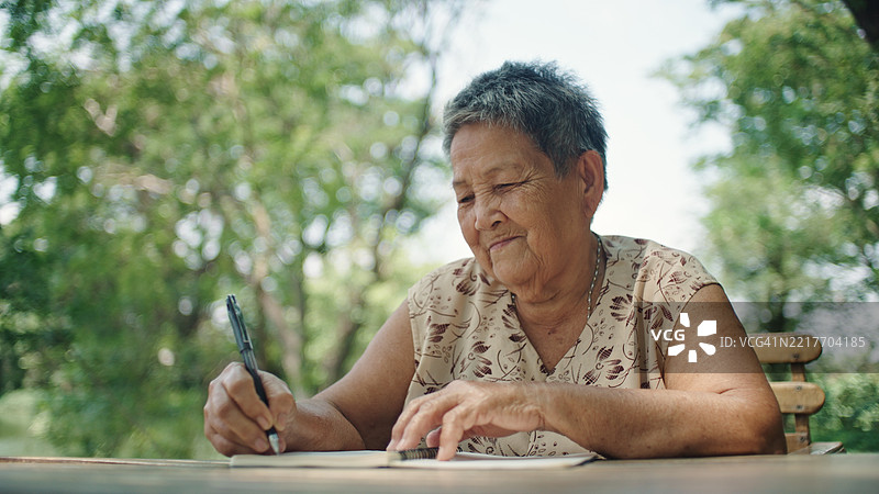 在大自然中写作的老年女性图片素材