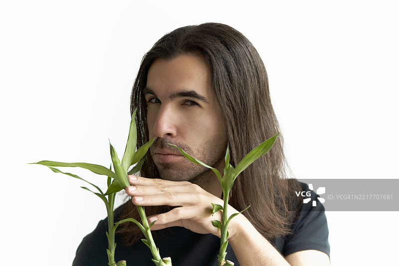 长发年轻人手持竹子植物图片素材