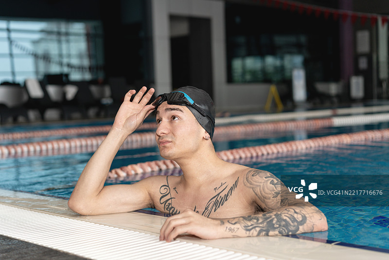 男性游泳教练，骄傲地在游泳池进行训练指导图片素材