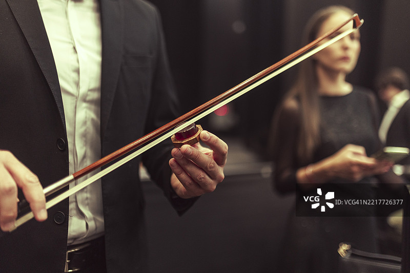 弦乐四重奏为演出做准备，练习音符并清洁和上油弓弦。图片素材