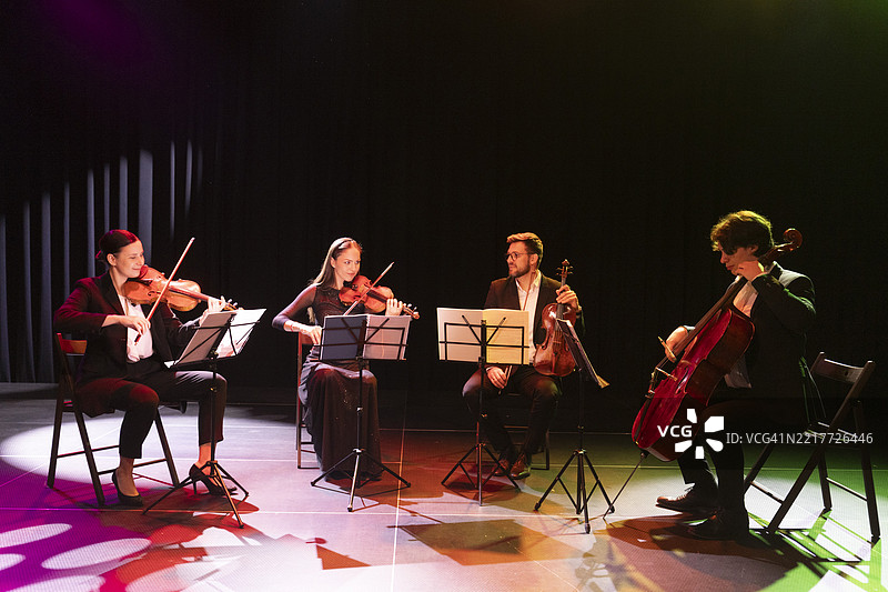 才华横溢的音乐家们在舞台上演奏乐器，互相对视，创造出优雅的艺术。图片素材