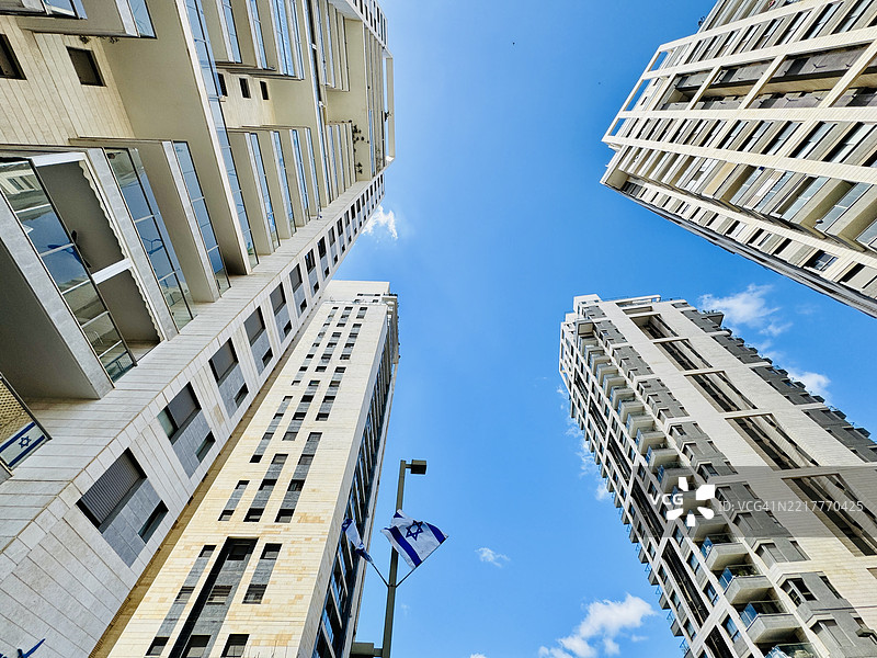 向上俯视现代住宅高层建筑，背景是晴朗的蓝天图片素材