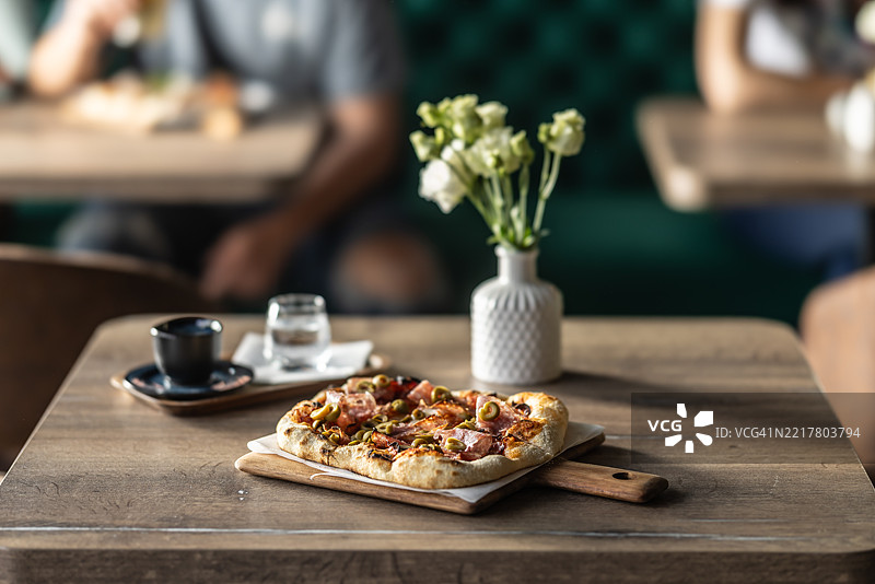 新鲜披萨放在餐厅或比萨店的桌子上。图片素材