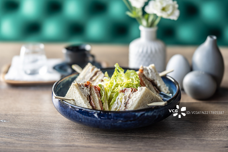 餐厅盘子里的烤面包配鸡肉培根和生菜，作为早餐菜肴。图片素材