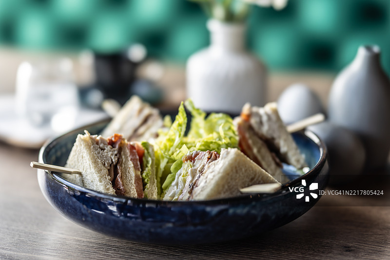 餐厅盘子里的烤面包配鸡肉培根和生菜，作为早餐菜肴。图片素材