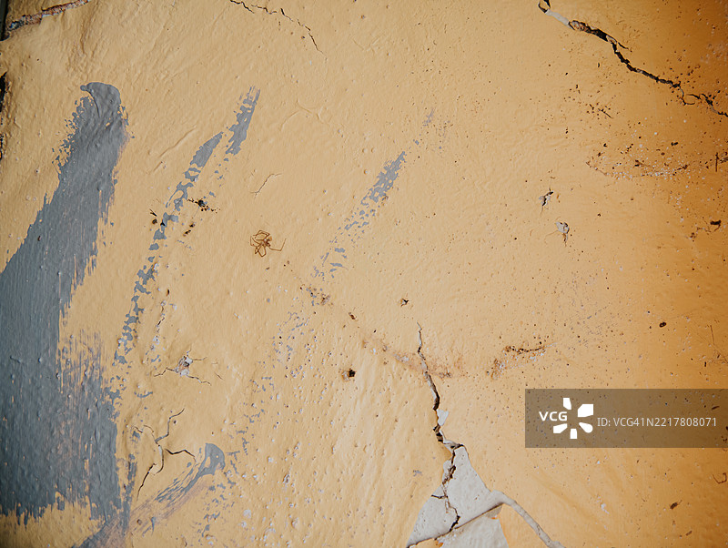 受损的混凝土背景，涂有剥落的黄色油漆纹理图片素材