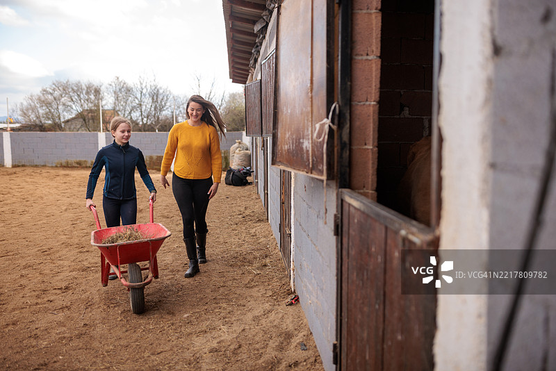 姐妹在牧场参观期间喂马图片素材