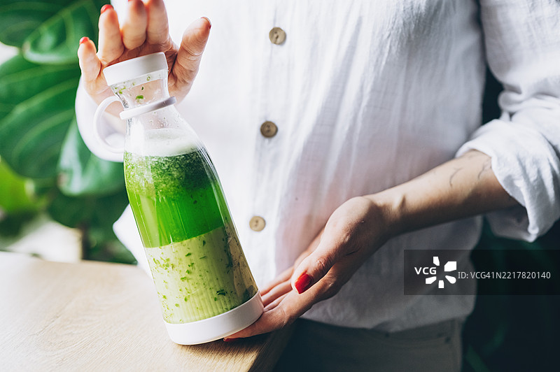 孕妇将生食材放入搅拌机中制作新鲜自制水果奶昔图片素材