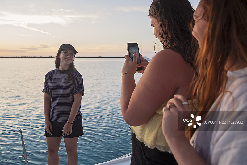 一群身材各异的年轻女性在日落时分的船上。图片素材