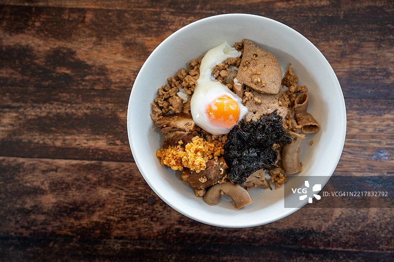 泰式美食风格。白碗里的干煮米饭配红烧肉、脆皮肉和剁碎的猪肉，早餐和晚餐的美味佳肴。图片素材