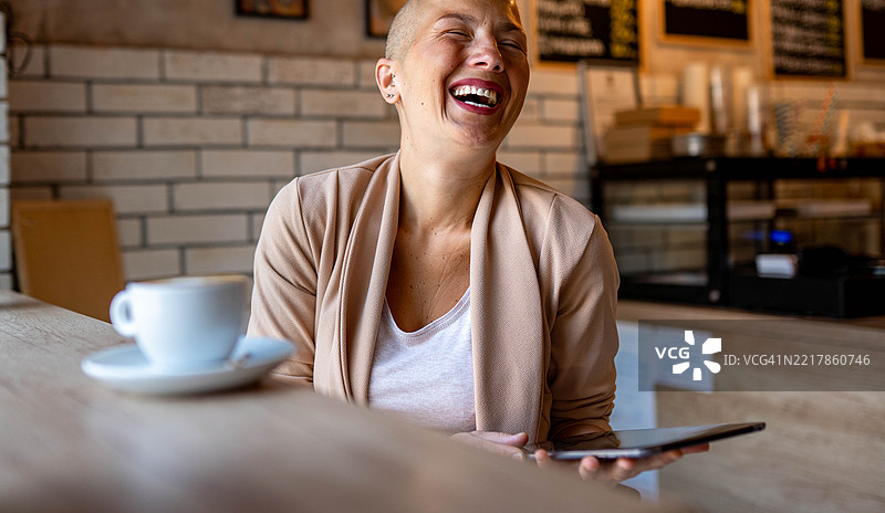 在咖啡店里用笔记本电脑工作的女性图片素材