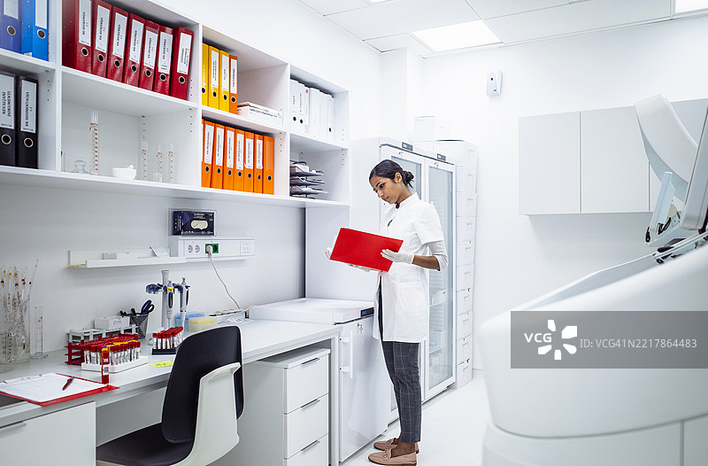 年轻的印度女性科学家穿着白色实验室外套，在现代实验室中工作图片素材