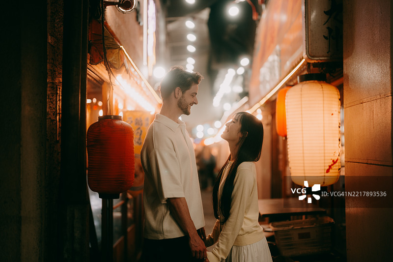 在东京小巷中夜晚快乐的情侣图片素材