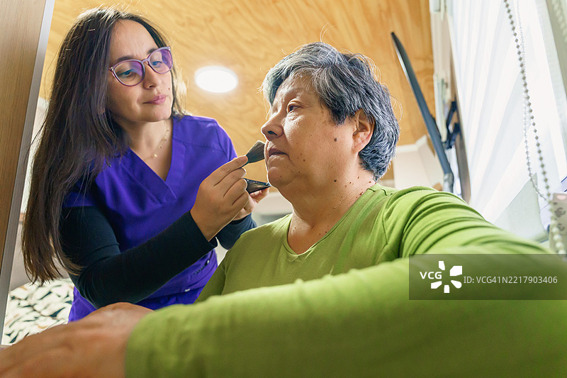 护理人员在家为老年女性化妆图片素材